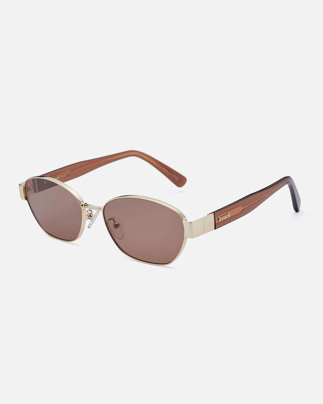 Alternate side angle of innsol Bate sunglasses featuring metal oval cat eye frame, adjustable nose pads, and refined temple detail in gold