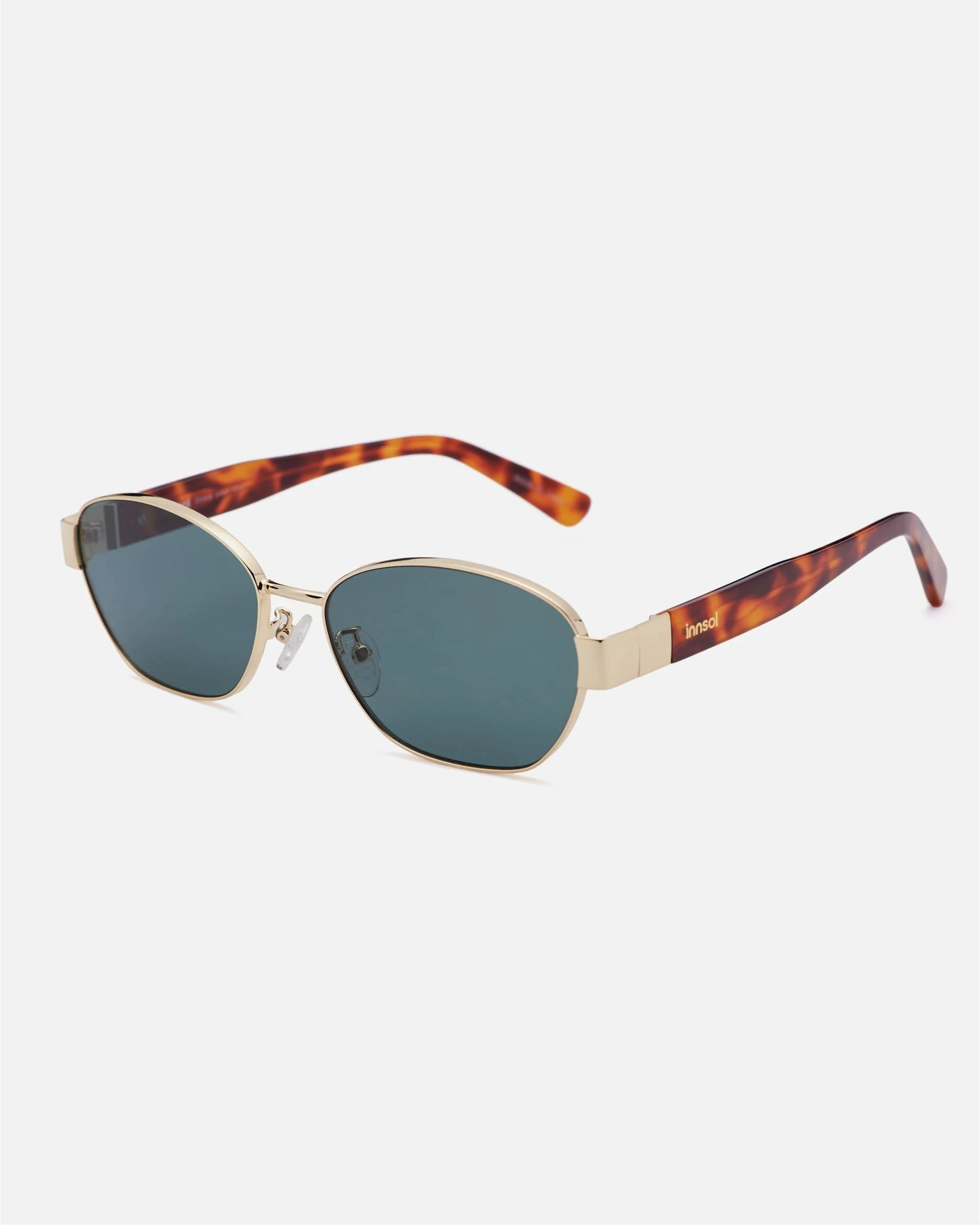 Alternate side angle of innsol Bate sunglasses featuring metal oval cat eye frame, adjustable nose pads, and refined temple detail in gold