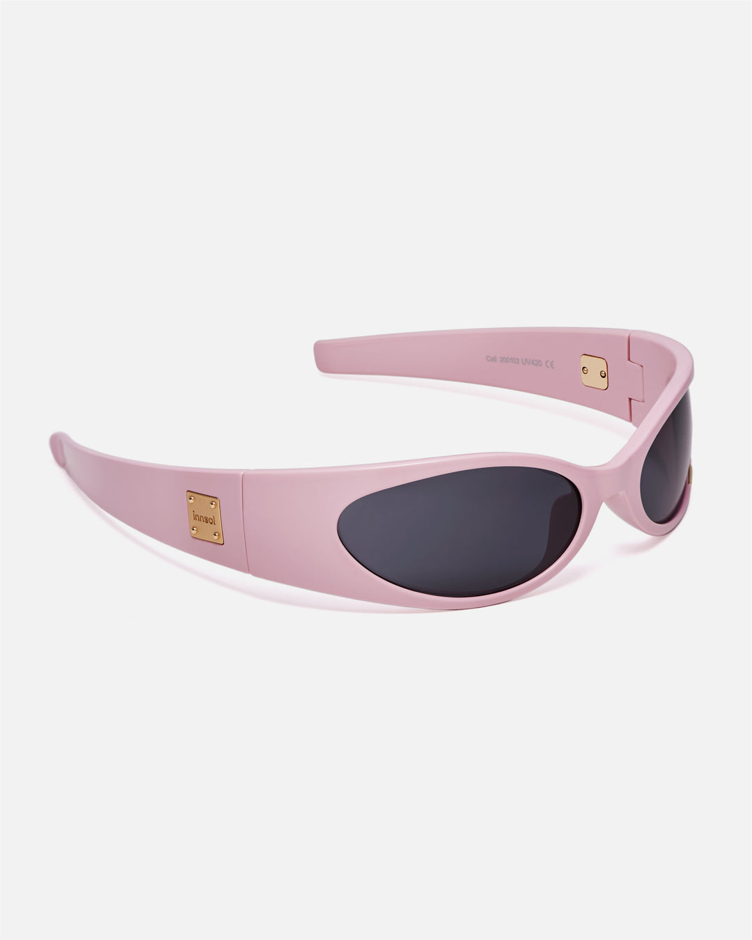 Angled view of innsol Cail Solid Pink sunglasses with gray lenses